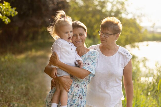 Grandmother, mom and baby in nature