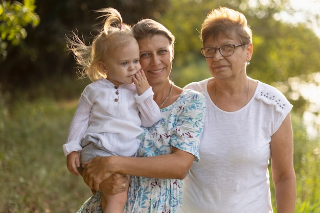 Grandmother, mom and baby in nature