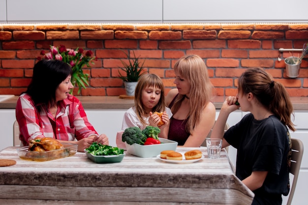 Бабушка, мама и внучки проводят время на кухне