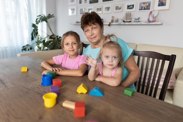 Фото Бабушка играет за столом с внуками дома