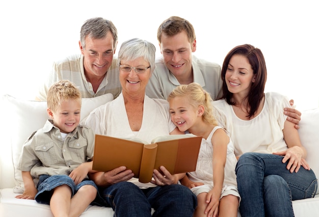 Photo grandmother reading a book to her family