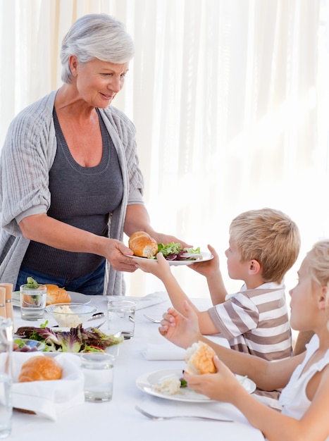 Grandmother serving her grandchildren