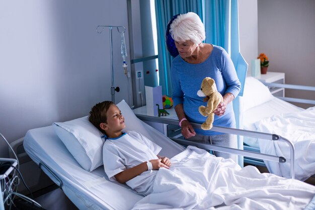 Grandmother showing teddy bear to grandson