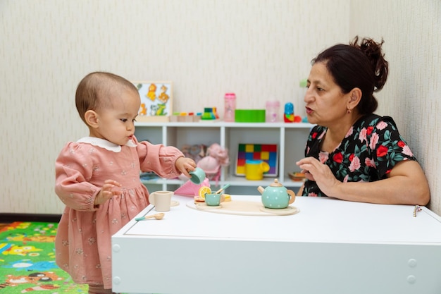 Grandmother and toddler playing with toys at home