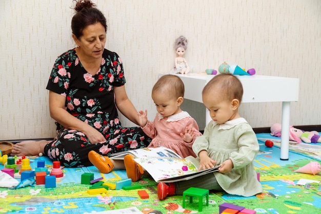 Photo grandmother and toddler reading books at home