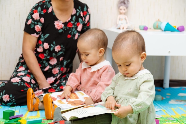 Photo grandmother and toddler reading books at home