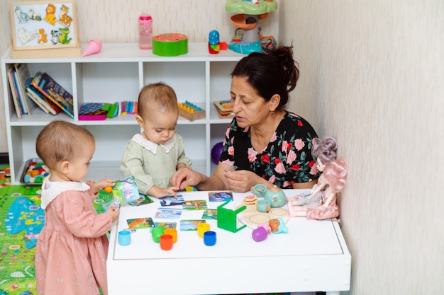 Grandmother and toddlers playing with matching puzzle