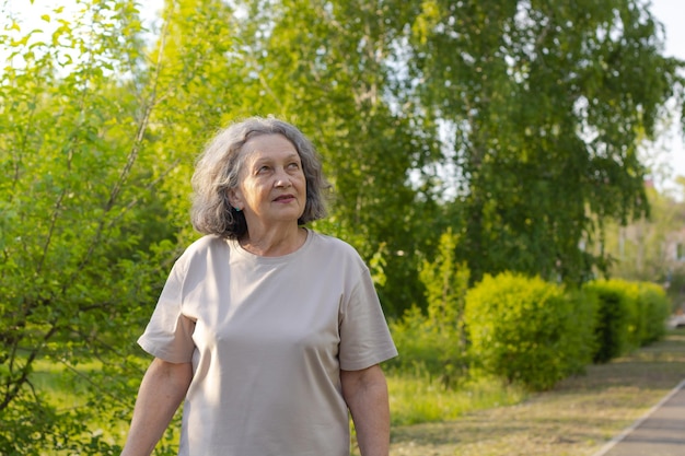 Grandmother walks in the park and looks up retirement age