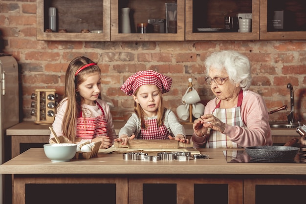 Бабушка с внучками пекут печенье