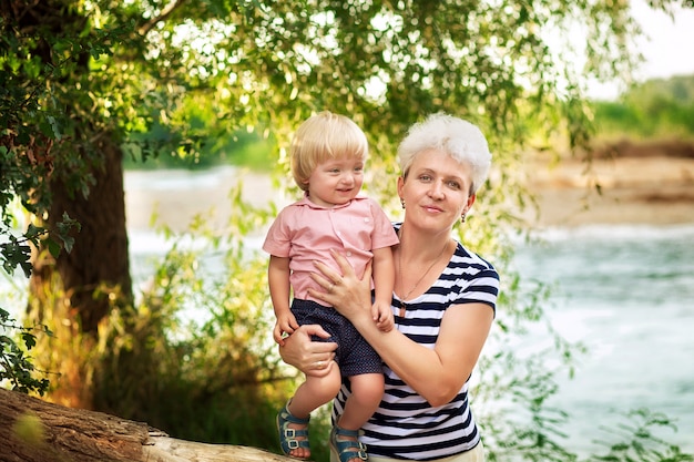 Grandmother with a grandson in nature in summer