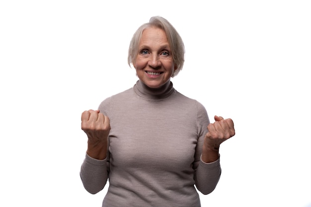 Grandmother with gray hair experiences happiness against a background of copy space