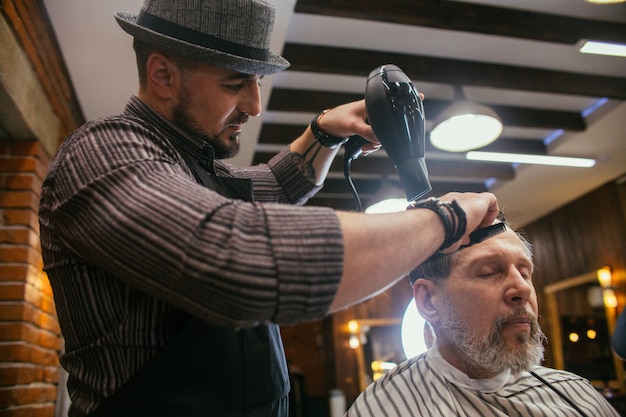 Grandpa gets a haircut at the hairdresser in Barber shop, Trendy haircut 