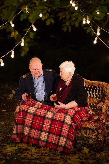 Grandpa and grandma drink tea in the Park.