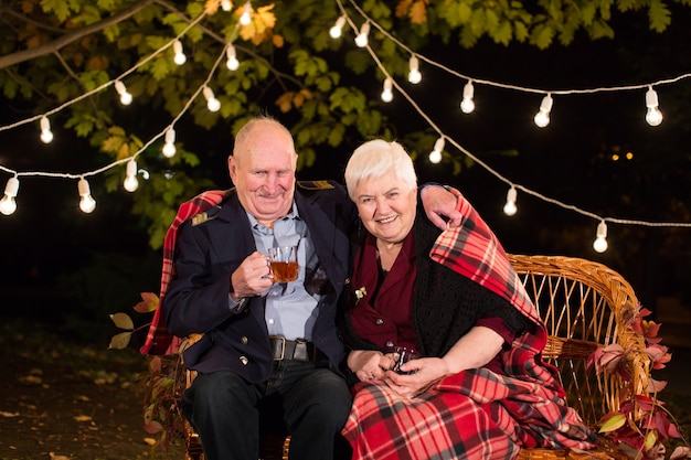 Grandpa and grandma drink tea in the Park.