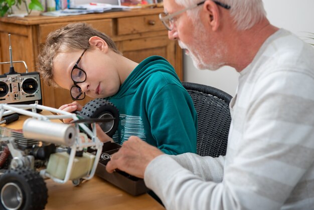 Grandpa and son little boy repairing a model radio-controlled car