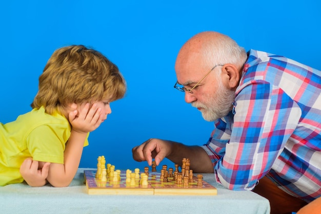 Grandpa teaching his grandson to play chess child playing intelligent game senior man thinking about