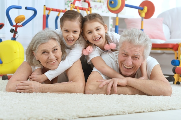 Бабушки и дедушки и маленькие внучки делают упражнения дома