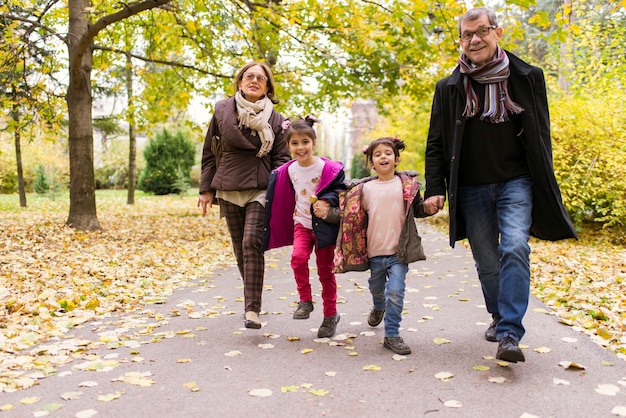 Nonni con i nipoti nel parco di autunno