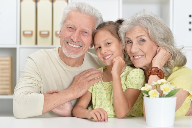 Grandparents with her granddaughter posing at home