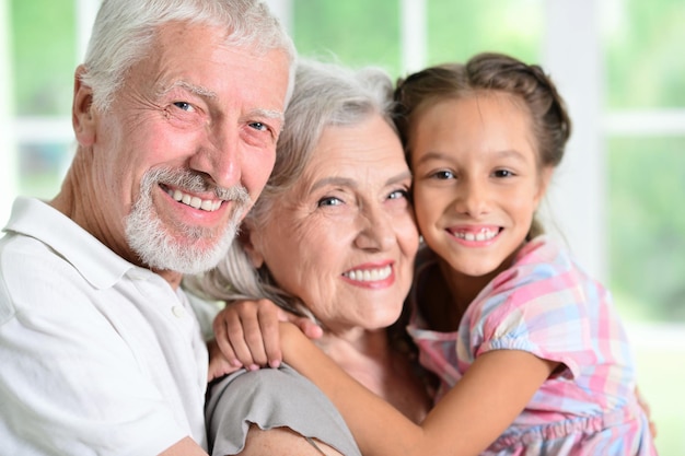 Grandparents with her granddaughter posing at home