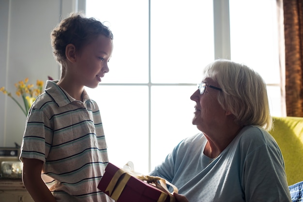 Photo grandson giving a gift to his grandma