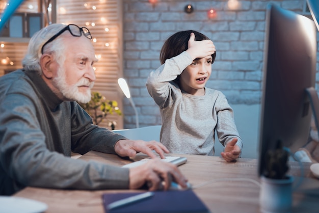 Grandson Teaching a Grandpa How to Use Computer