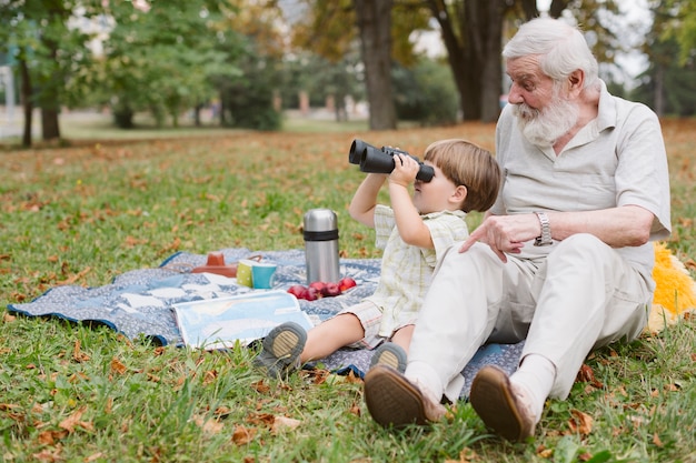 Nipote con il nonno guardando attraverso il binocolo