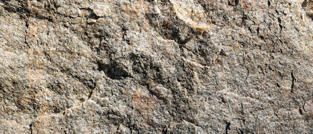 Granieten steen textuur. Gebarsten granieten rotsoppervlak. Natuursteen achtergrond. Detailopname