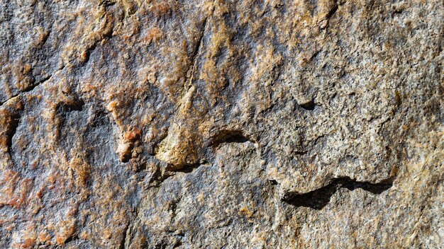 Granite rock texture. Cracked granite surface from weathering. Close-up of stone surface. Earth color concept