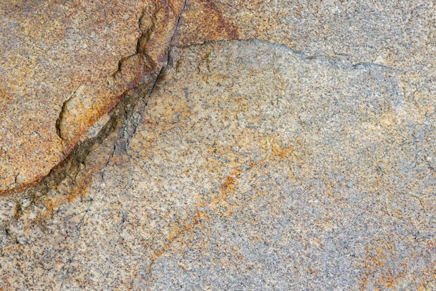 Granite rock texture. Cracked granite surface from weathering. Close-up of stone surface. Earth color concept