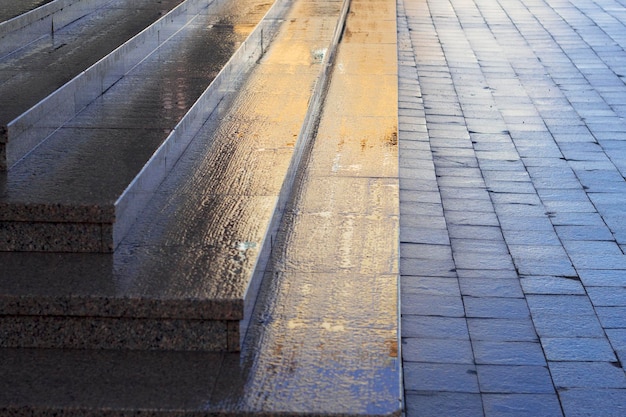 granite steps in the city center with yellow sunlight and blue shadows