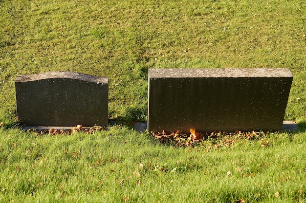 Granite tombstones and a green lawn in the cemetery.