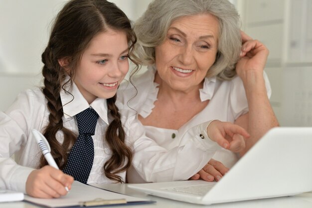 Granny with granddaughter using laptop, close up