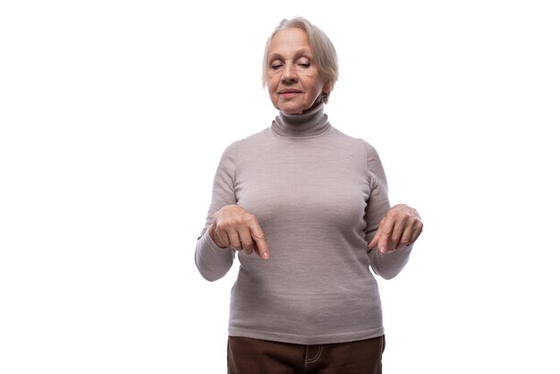 Foto la nonna con i capelli grigi mostra il dito sullo sfondo bianco