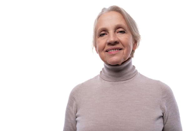 Photo granny with gray hair smiling sweetly in studio with white background