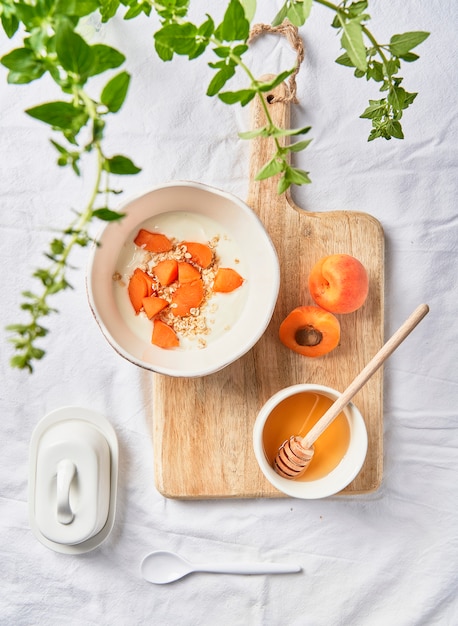 Granola and apricot breakfast on a white linen tablecloth