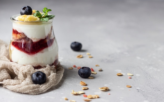 Granola, blueberry and banana greek yogurt parfaits in mason jars 