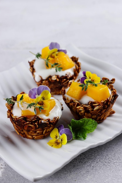 Granola cups gevuld met yoghurt en mango