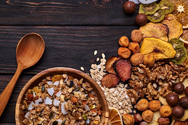 Foto muesli e frutta secca con noci su un tavolo di legno