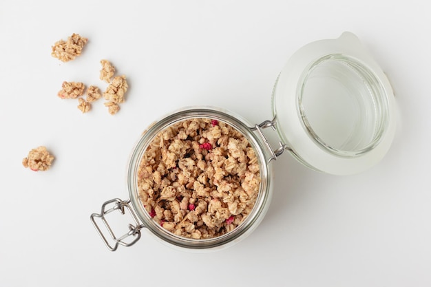 Granola in jar on light background