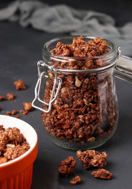 Granola krokante muesli met natuurlijke honing, chocolade en noten in een glazen pot