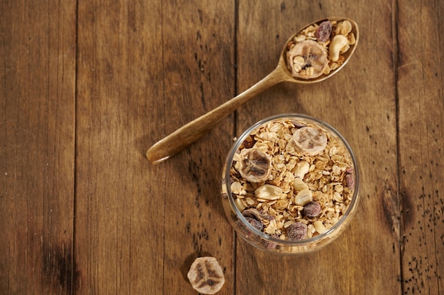 Granola met gedroogde vruchten in een pot op een houten tafel