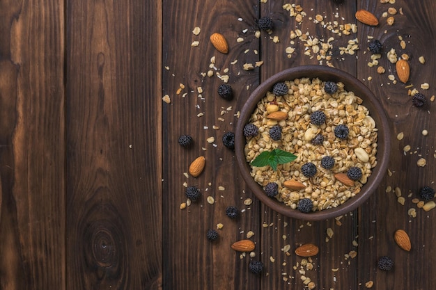 Granola met muntamandelen en frambozen in een kleikom op tafel