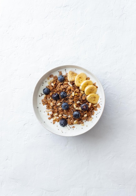 Foto granola met yoghurt, bosbessen, noten, banaan en honing. muesli. gezond eten. vegetarisch eten.
