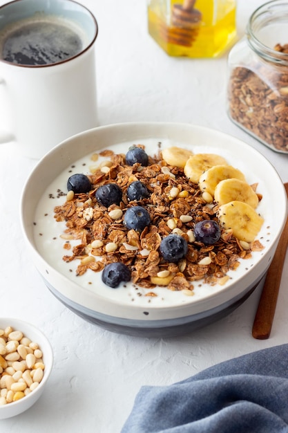 Foto granola met yoghurt, bosbessen, noten, banaan en honing. muesli. gezond eten. vegetarisch eten.