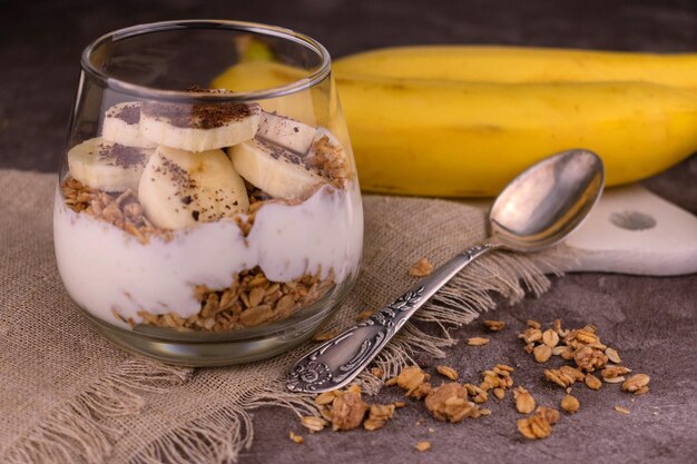 Granola met yoghurt en banaan in een glas Gezond dessertsconcept