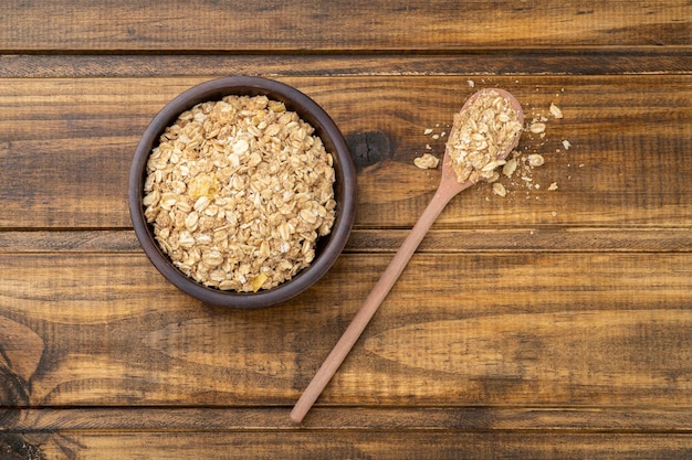 Granola or muesli on a bowl and on a spoon over wooden table