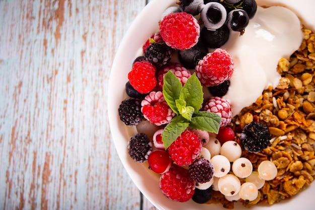 Granola muesli cereals with yogurt or milk and fresh berries Healthy breakfast concept