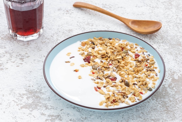 Granola, oatmeal with milk, honey and strawberry on blue plate