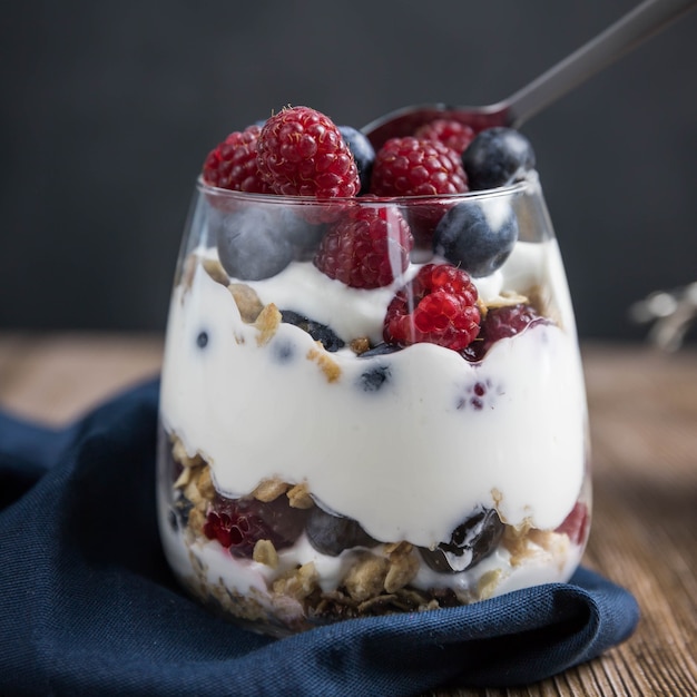A granola parfait with berries and yogurt  on a black background